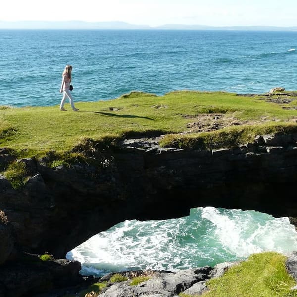 Walking the clifftop above a sea arch on the Atlantic coast
